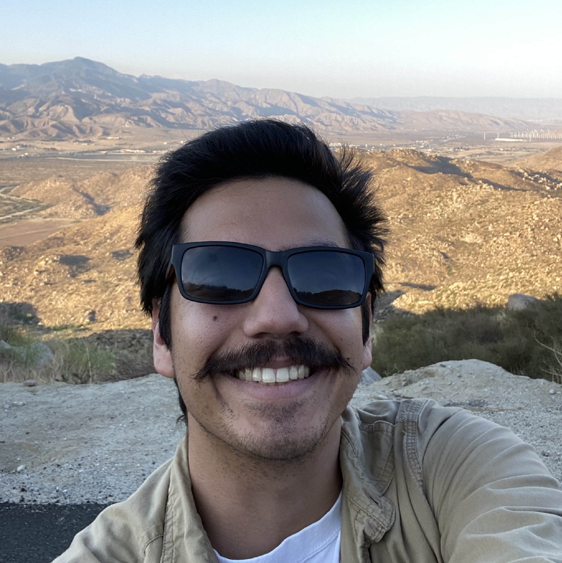 Casual picture of Andrew Winter with sunglasses standing near a cliff edge
